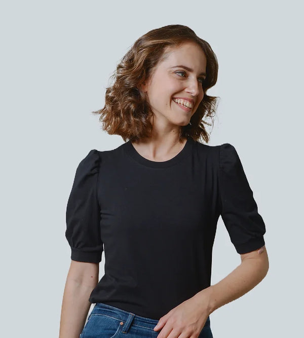 Model wearing a black Megan T-shirt, standing against a minimalist background