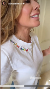 woman wearing a white t-shirt with embroidered text "be cool be kind"